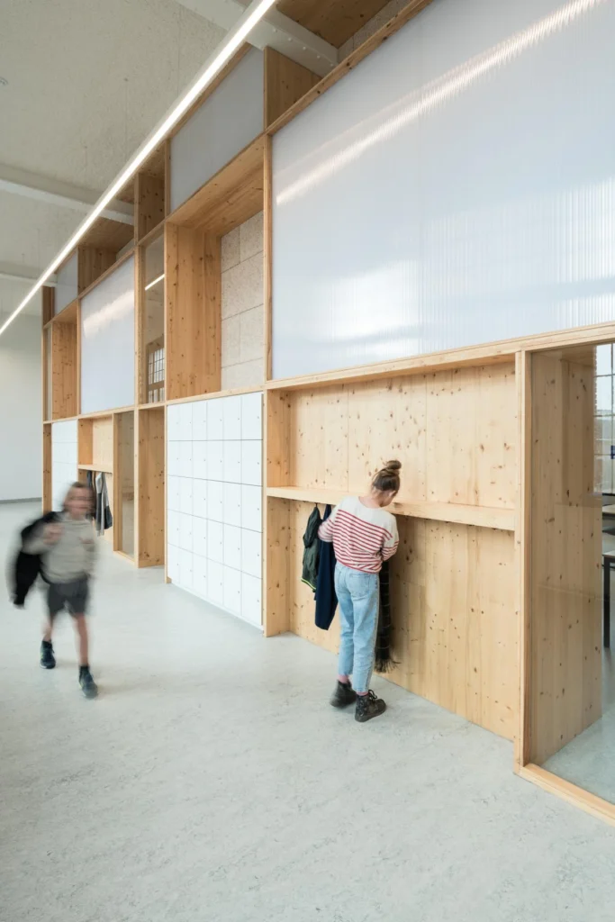 Een ingebouwde kast en kapstok op een school met kinderen ervoor