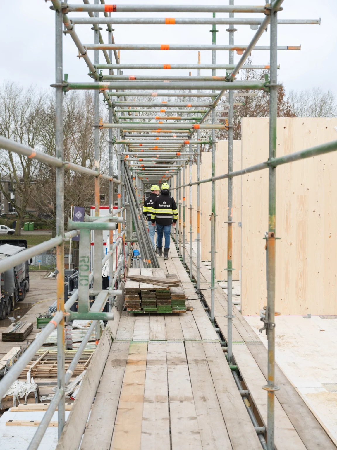 Rembrandtweg Linkwood medewerkers lopen over de steiger langs de houten gevel