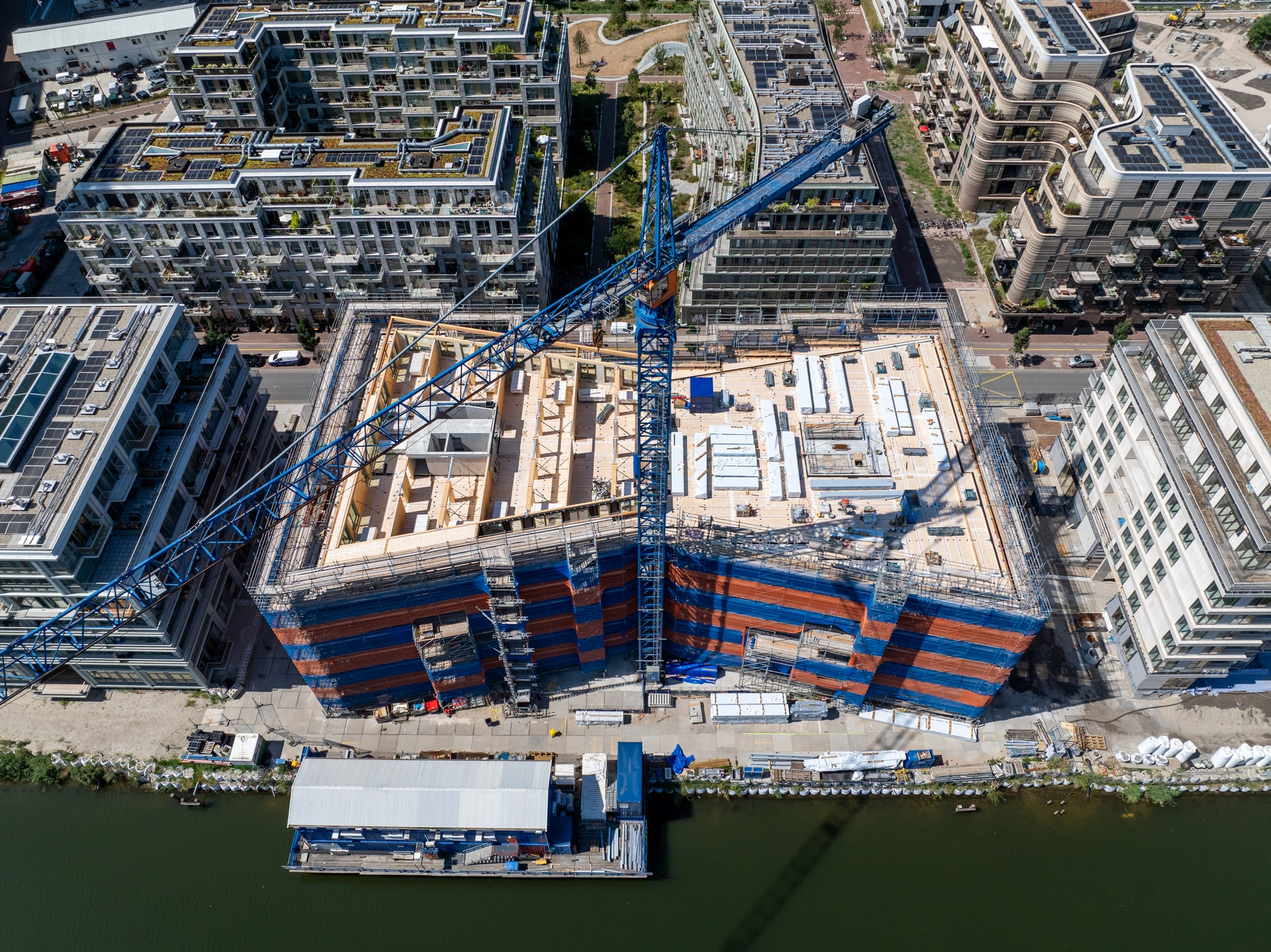 The Ark droneshot van de bouwplaats aan het IJ met de bouwkraan boven het houten gebouw