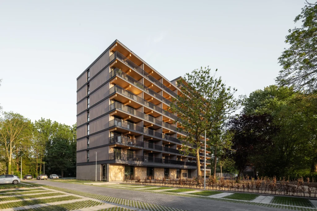 Valckensteyn voorgevel met houten balkons in de avondzon tussen de bomen