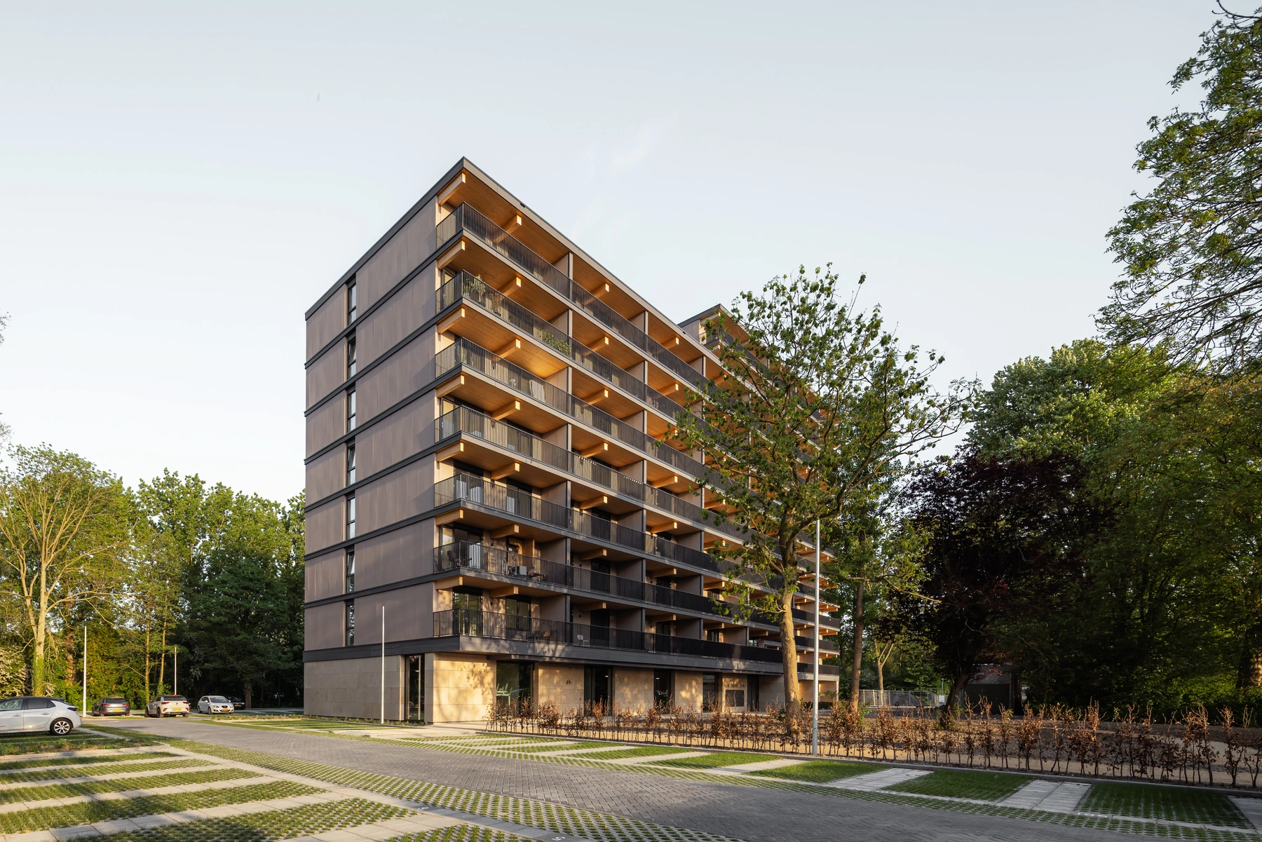 Valckensteyn voorgevel met houten balkons in de avondzon tussen de bomen