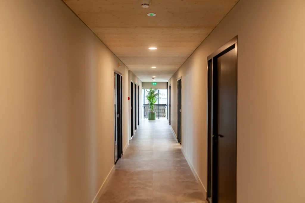 gang met houten plafond en zwarte deuren in het kantoor van Linkwood