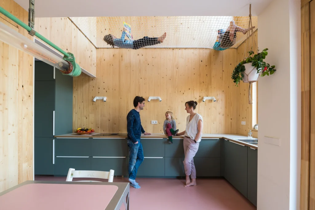 keuken met houten wanden waarin kinderen in een net boven het aanrecht liggen te lezen