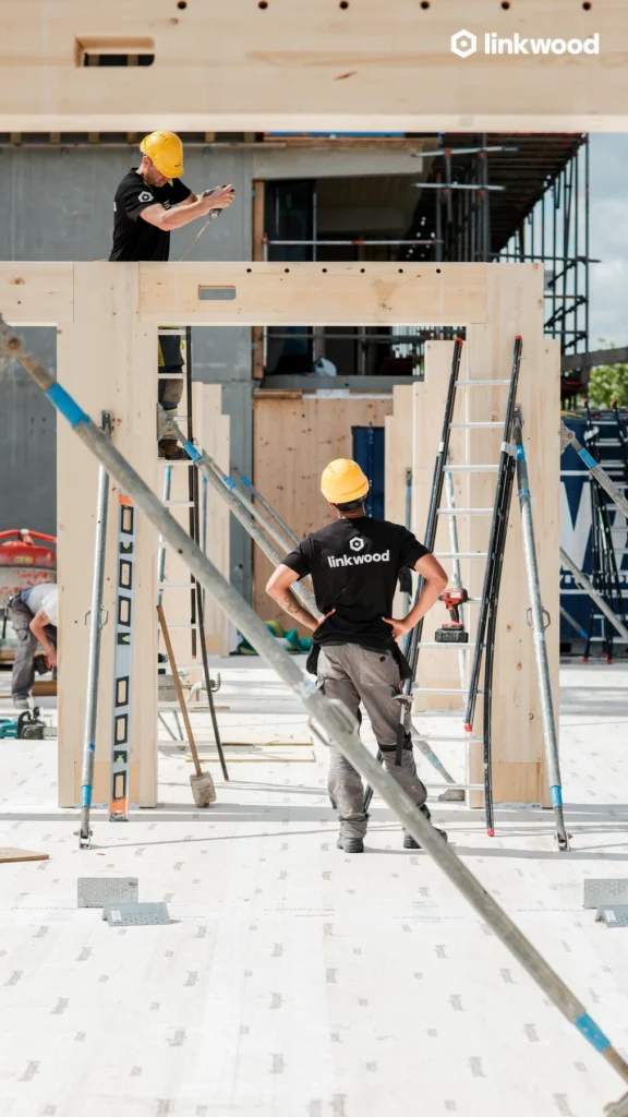 twee Linkwood medewerkers monteren een houten ligger op de bouwplaats